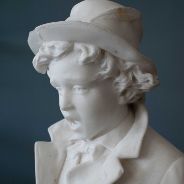 19th-century carved marble bust of a boy in a bowtie and feathered hat