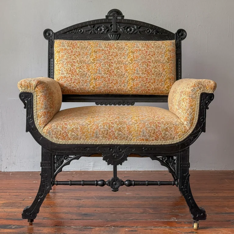 Ebonized Aesthetic Movement arm chair, circa 1880, carved crest rail