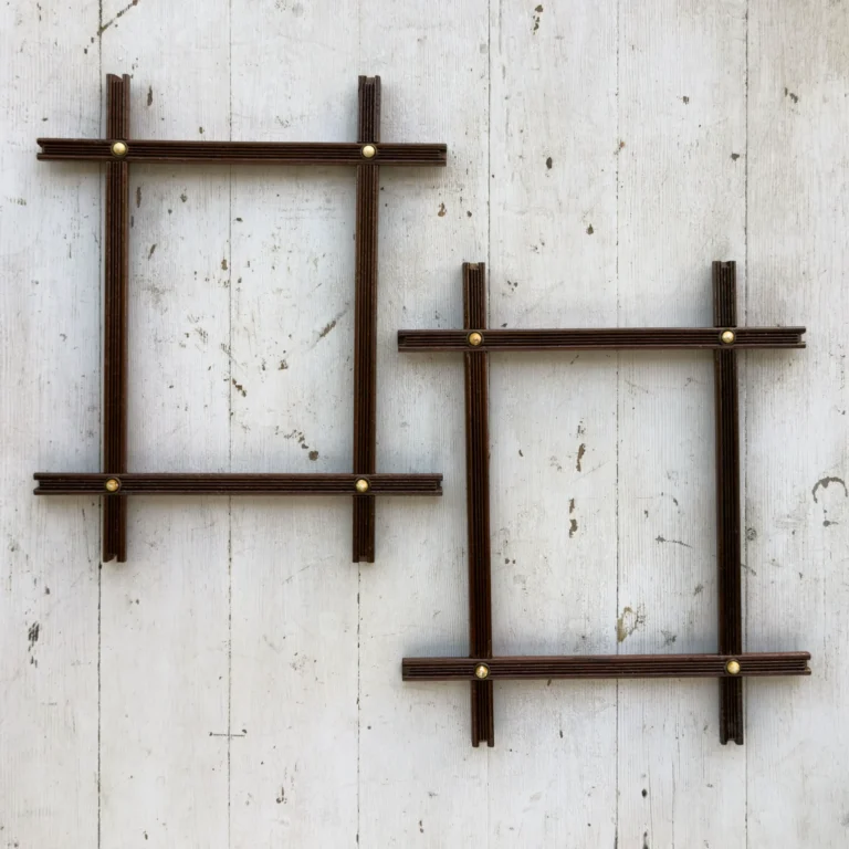 Pair of antique Adirondack-style cross-corner picture frames with reeded wood and brass corner bosses